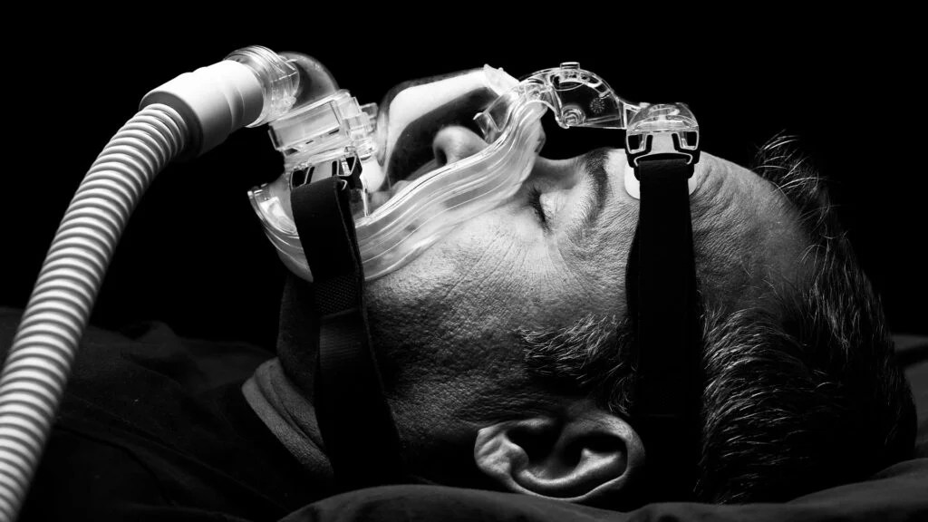 A man breathing through a CPAP machine while sleeping